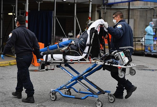 Nhân viên y tế chuyển bệnh nhân nhiễm COVID-19 tới bệnh viện Brooklyn ở New York (Mỹ) (Ảnh: AFP/TTXVN)