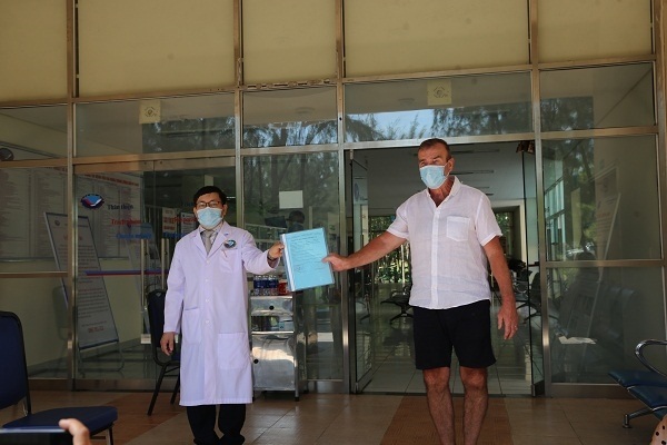 Bác sĩ Đinh Đạo (bên trái) trao giấy chứng nhận ra viện cho bệnh nhân thứ 57
