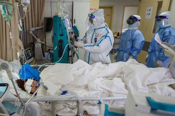 Các bác sĩ điều trị cho một bệnh nhân ở Vũ Hán (Ảnh: AFP)