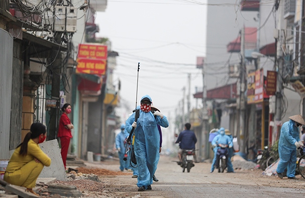 Lực lượng chức năng phun khử khuẩn toàn bộ ngõ có 12 hộ dân nơi bệnh nhân sinh sống và thôn Đông Cứu (xã Dũng Tiến, huyện Thường Tín)