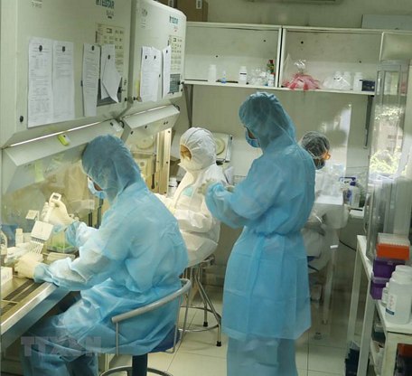 Nhân viên Viện Pasteur Thành phố Hồ Chí Minh miệt mài trong phòng xét nghiệm tìm virus SARS-CoV-2.