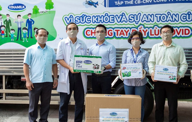 Anh Nguyễn Quang Thái (đứng giữa) đại diện công ty trao tặng sữa cho các trẻ em có hoàn cảnh khó khăn cần giúp đỡ trong dịch Covid-19 vừa qua