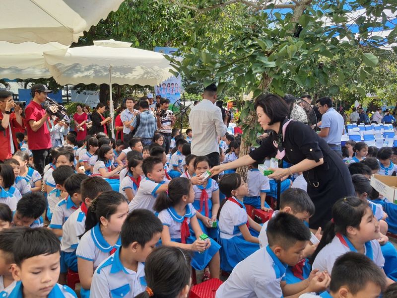 Các em học sinh trường Kim Đồng nhận những hộp sữa từ Vinamilk và các đại biểu tham dự chương trình