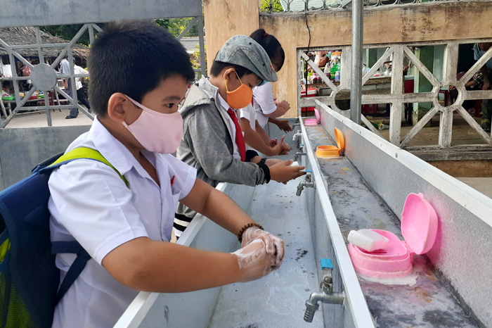 Học sinh được hướng dẫn đeo khẩu trang ở nơi đông người và rửa tay trước khi vào lớp học
