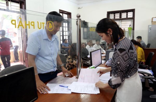 Cán bộ Trung tâm hành chính công Yên Lạc tận tình hướng dẫn người dân làm thủ tục hành chính (ảnh Thanh Nga)