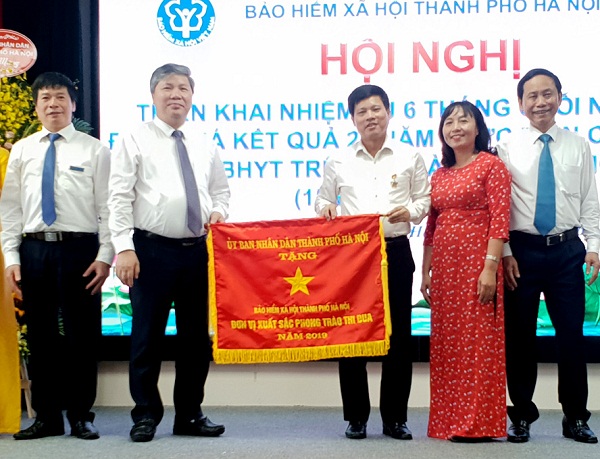 Đại diện BHXH thành phố đón nhận Cờ đơn vị xuất sắc phong trào thi đua năm 2019 của UBND thành phố Hà Nội
