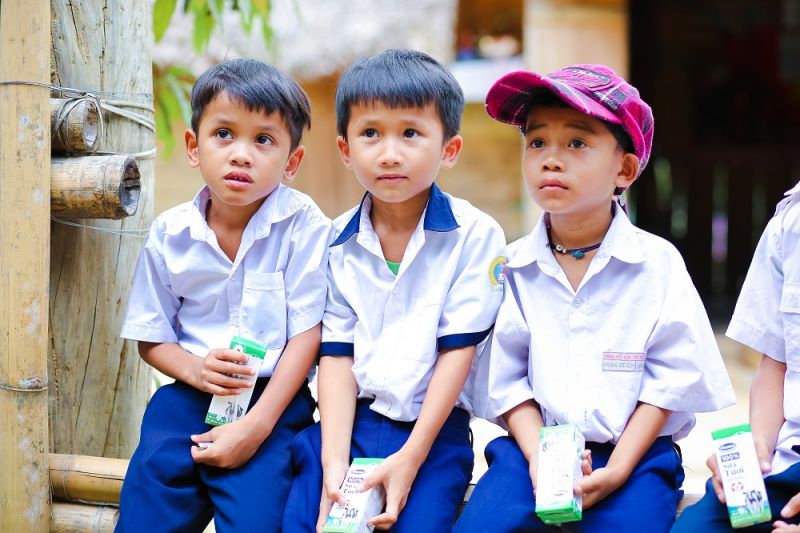 Các em học sinh huyện Đông Giang nhận những hộp sữa đầu tiên khi đến lớp theo chương trình Sữa học đường