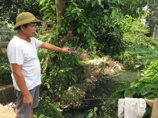 Ông Trần Văn Phúc và nhiều hộ gia đình đang khổ sở vì phải sống chung với mương nước ô nhiễm