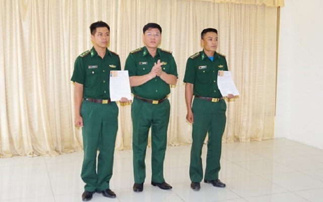 Đại tá Hoàng Văn Hùng, Phó Chính ủy BĐBP Thanh Hóa (giữa) trao Quyết định và Giấy chứng nhận thương binh cho 2 cán bộ. Ảnh: Xuân Thủy