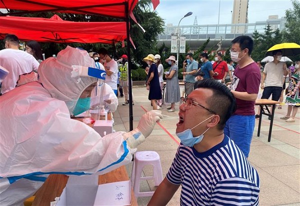 Nhân viên y tế lấy mẫu xét nghiệm Covid-19 tại Đại Liên, tỉnh Liêu Ninh, Trung Quốc (Ảnh: AFP/TTXVN)