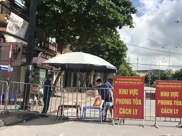 Người dân trong khu vực phong tỏa trên phố Ngô Quyền (Hải Dương) nhận thực phẩm tiếp tế tại hàng rào cách ly ngày 16/8.