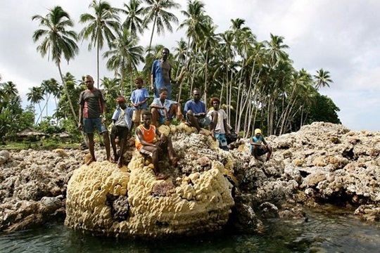 Cư d&acirc;n ngồi tr&ecirc;n một rặng san h&ocirc; ở đảo Ranongga của Solomon. Ảnh: AFP