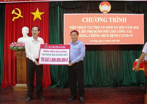 Ông Bùi Thanh Quang (bên trái) - Giám đốc Agribank chi nhánh tỉnh An Giang - đại diện Agribank trao tặng 100 nhà Đại đoàn kết cho tỉnh An Giang