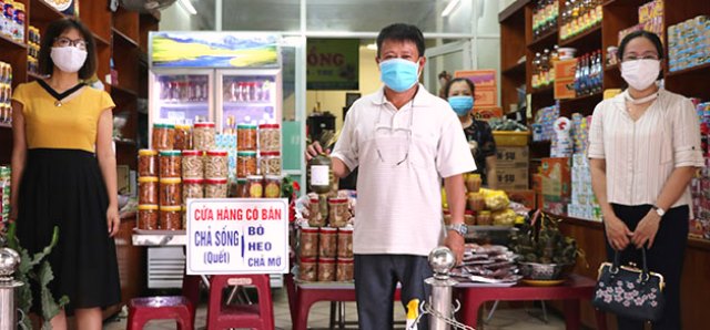 Ông Trần Hùng (giữa) bên sản phẩm được “gắn sao” OCOP do UBND quận Hải Châu, TP. Đà Nẵng công nhận.