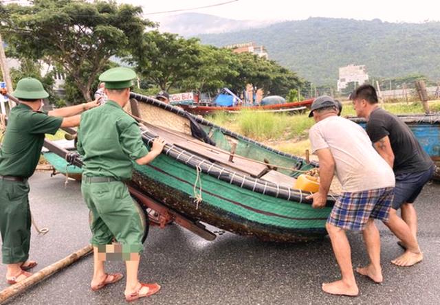 Bộ đội giúp ngư dân đưa phương tiện đánh cá lên bờ tránh bão tại bãi biển Thọ Quang