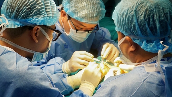 Phó giáo sư Trần Trung Dũng và ekip bác sĩ Trung tâm Phẫu thuật khớp - Y học thể thao Bệnh viện Đa khoa Tâm Anh, Hà Nội phẫu thuật thay đồng loạt 8 khớp ngón tay bị biến dạng cho bệnh nhân Trần Thị Ánh