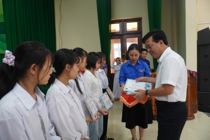 Ông Ngô Văn Đông, Tổng giám đốc Phân bón Bình Điền trao học bổng cho các em. (Ảnh: Ngọc Vân)