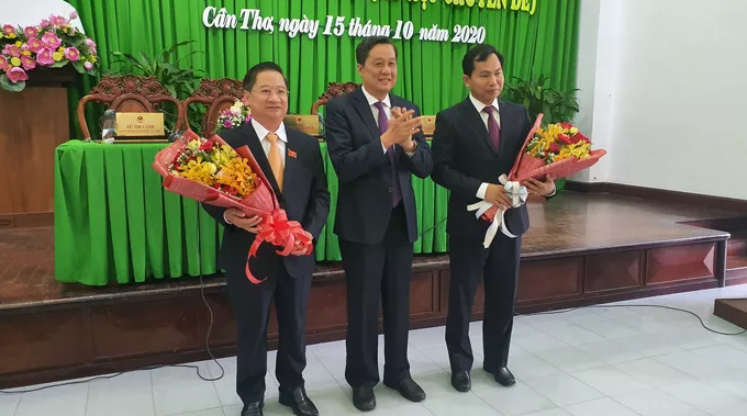 Ông Trần Việt Trường (bìa trái) và ông Lê Quang Mạnh (bìa phải) nhận hoa chúc mừng.