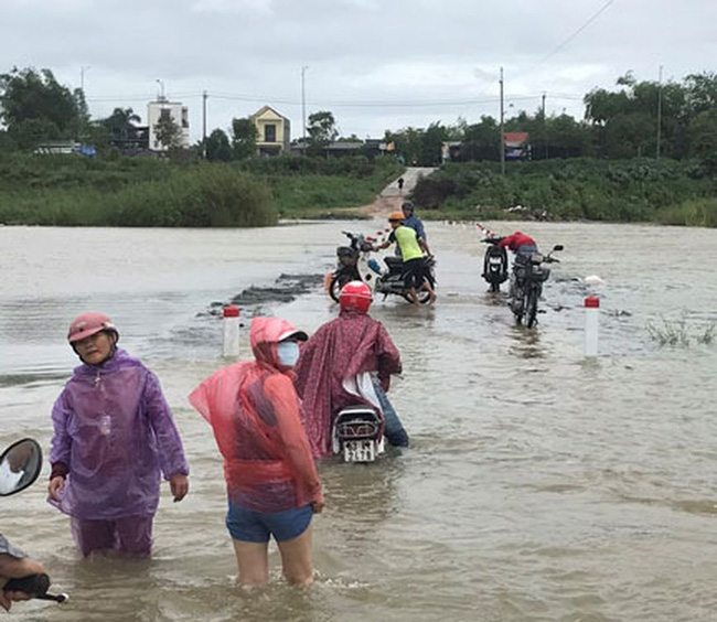 Người dân xã Tịnh An, TP Quảng Ngãi lội qua đoạn sông Trà Khúc bị nước lũ chia cắt