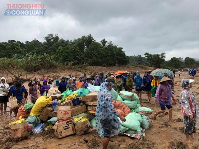 Rất đông người dân tập trung tại điểm tập kết hàng ven sông để tiếp nhận cứu trợ