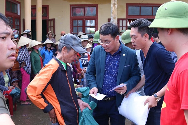 Ông Nguyễn Ngọc Quyết (ở giữa) - TBT Tạp chí Điện tử Hòa nhập trao quà cứu trợ cho bà con nhân dân vùng lũ thôn Phú Hòa, xã Phú Thuỷ, huyện Lệ Thuỷ, Quảng Bình.