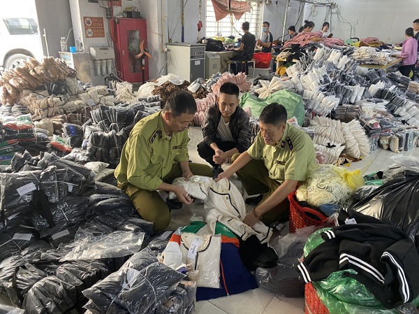 Lực lượng QLTT Hà Nội bắt quả tang cơ sở gia công sử dụng máy may, máy vắt sổ sản xuất quần áo nhái thương hiệu nổi tiếng