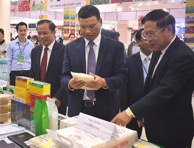 Phó Chủ tịch UBND Hồ Kỳ Minh (thứ hai, từ phải sang) thăm gian hàng trưng bày tại EWEC 2020 của doanh nghiệp đến từ nước bạn Lào.