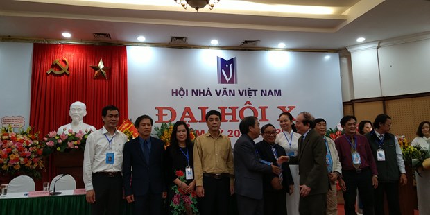 Nhà thơ Hữu Thỉnh chúc mừng tân chủ tịch Hội nhà văn và Ban chấp hành mới. (Ảnh: Minh Thu/Vietnam+)