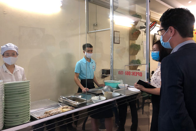 Cán bộ Chi cục An toàn vệ sinh thực phẩm Hà Nội kiểm tra công tác bảo đảm an toàn thực phẩm tại một quán phở trên địa bàn quận Cầu Giấy (Ảnh: Trang Thu)