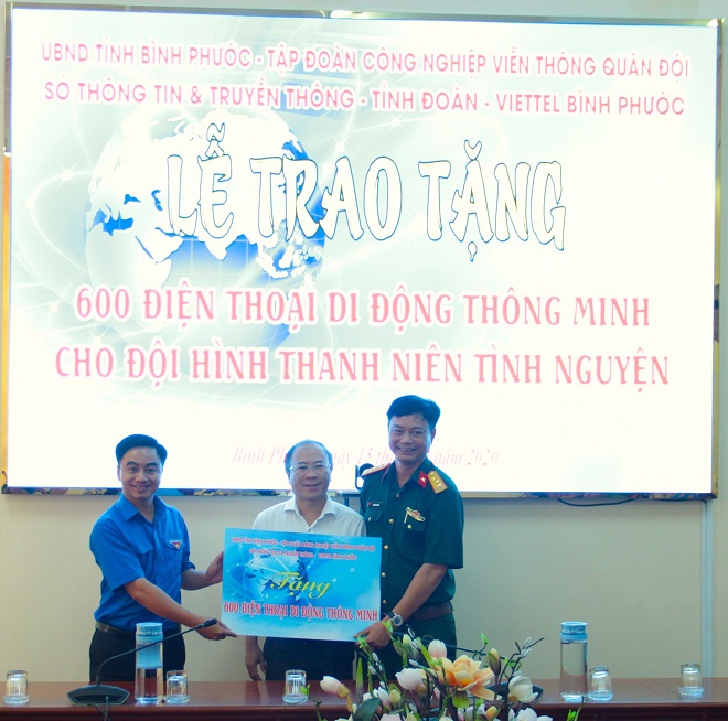 Bí thư Tỉnh Đoàn Bình Phước Trần Quốc Duy (bên trái, ngoài cùng) nhận bảng tượng trưng 600 chiếc điện thoại thông minh