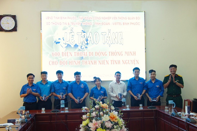 Đại diện các đội hình thanh niên tình nguyện hào hứng khi được ông Chu Hồng Quảng - Giám đốc Viettel Bình Phước (bên phải, ngoài cùng) trao tặng các điện thoại di động thông minh