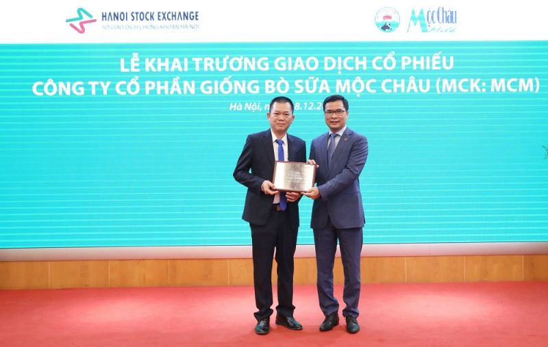 Lãnh đạo Sở Giao dịch chứng khoán Hà Nội (phải) trao chứng nhận đăng ký giao dịch cho Tổng giám đốc công ty Mộc Châu Milk (trái).