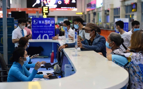 Hành khách làm thủ tục tại quầy Vietnam Airlines trong sân bay Tân Sơn Nhất (TP.HCM) - Ảnh: QUANG ĐỊNH