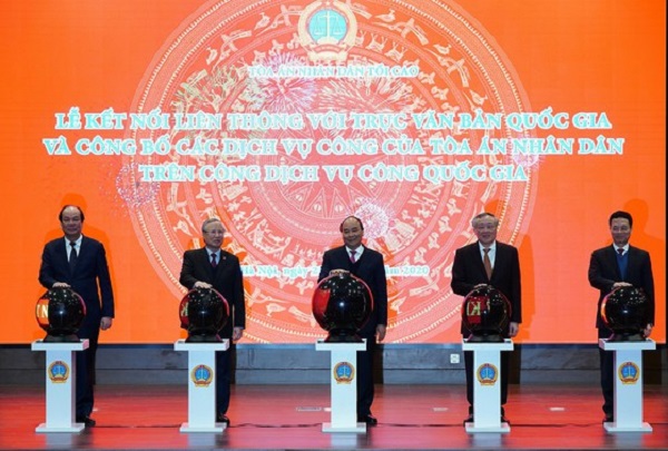 Thủ tướng Nguyễn Xuân Phúc và các đại biểu bấm nút kết nối liên thông với trục văn bản quốc gia và công bố các dịch vụ công của Tòa án nhân dân tích hợp trên Cổng dịch vụ công quốc gia. Ảnh: ĐỖ TRUNG