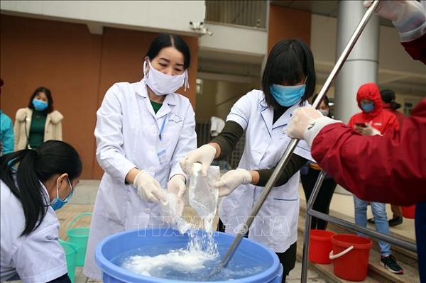Cán bộ y tế quận Hoàng Mai pha chế dung dịch khử trùng tại Trường Tiểu học Đại Kim, quận Hoàng Mai (Hà Nội) (Ảnh: Danh Lam/TTXVN)