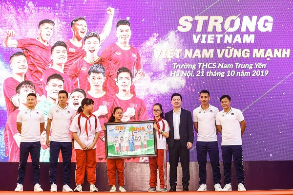 Các em học sinh Trường trung học cơ sở Nam Trung Yên tặng tranh cho các cầu thủ của Câu lạc bộ Bóng đá Hà Nội FC