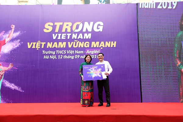 Đại diện Ban lãnh đạo CLB Bóng đá Hà Nội tặng quà cho nhà trường để sắm giáo cụ thể chất cho các em học sinh