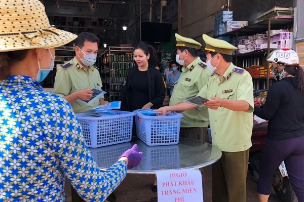 Phối hợp cùng các cá nhân, tổ chức cấp phát khẩu trang cho người dân (Ảnh: Cục QLTT Gia Lai)