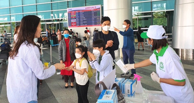 Du khách quốc tế đến Đà Nẵng nhận khẩu trang miễn phí và sử dụng nước sát khuẩn để vệ sinh tay ngay tại Cảng hàng không quốc tế Đà Nẵng
