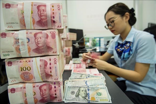 Kiểm đồng 100 Nhân dân tệ tại ngân hàng ở tỉnh Giang Tô, Trung Quốc (Ảnh: AFP/TTXVN)