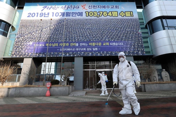 Nhân viên y tế phun thuốc khử trùng phía trước một nhà thờ của giáo phái Shincheonji ở Daegu, Hàn Quốc, nhằm ngăn chặn sự lây lan của Covid-19