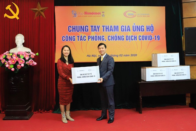 Đại diện Công ty cổ phần kinh doanh địa ốc Him Lam trao vật phẩm y tế phòng, chống dịch Covid-19 cho ông Trần Anh Tuấn - Phó Giám đốc Bưu điện Hà Nội.