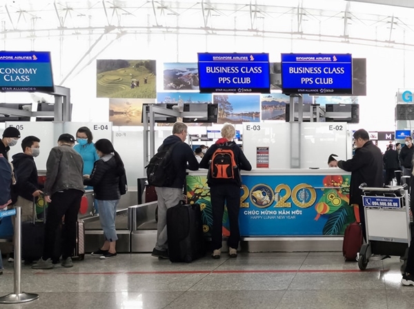 Nhân viên và hành khách đeo khẩu trang tại quầy làm thủ tục tại sân bay Nội Bài (Hà Nội), trong dịch covid-19, tháng 1/2020