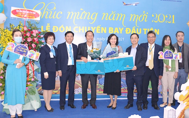 Đại diện lãnh đạo Sở Du lịch TP. Đà Nẵng và Hãng hàng không Quốc gia Việt Nam tặng quà cho hai vị khách may mắn trên chuyến bay đầu năm mới