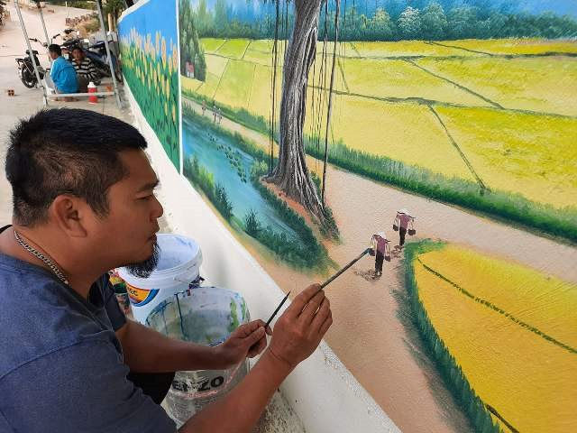 Anh Lê Văn Tĩnh, Giảng viên Trường Đại học văn hóa, Thể thao du lịch Thanh Hóa đang hoàn thiện bức tranh bích họa cuối cùng