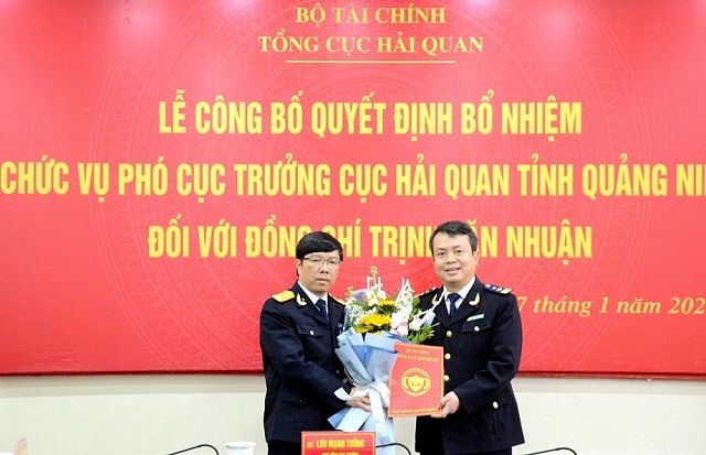 Phó Tổng cục trưởng Tổng cục Hải quan Lưu Mạnh Tưởng (bên trái) tặng hoa chúc mừng và trao quyết định bổ nhiệm cho ông Trịnh Văn Nhuận.