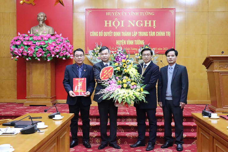 Bí thư Huyện ủy Vĩnh Tường Nguyễn Xuân Quang trao quyết định và tặng hoa chúc mừng Trung tâm Chính trị huyện.