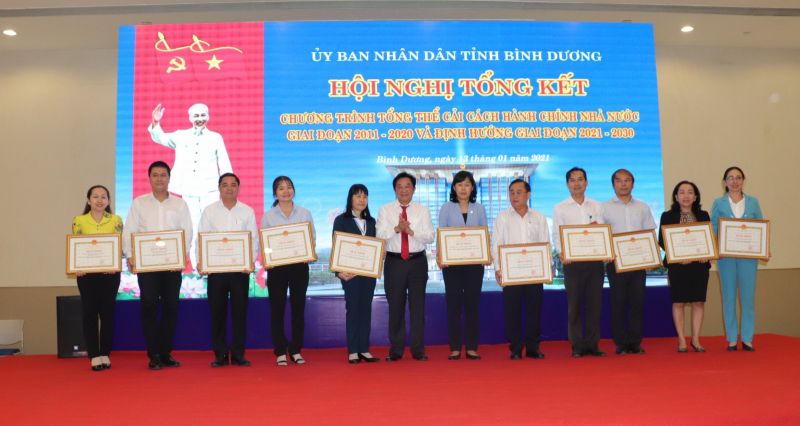Ông Nguyễn Hoàng Thao (thứ sáu từ trái qua), Phó Bí thư Tỉnh ủy, Chủ tịch UBND tỉnh, trao bằng khen của UBND tỉnh cho 11 tập thể có thành tích xuất sắc trong công tác CCHC giai đoạn 2011-2020. Ảnh: HỒ VĂN