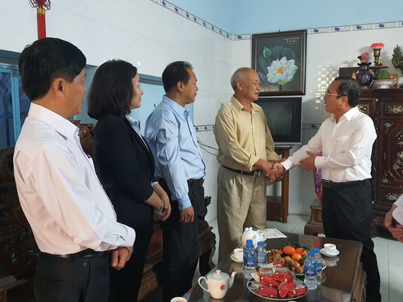 Bí thư Tỉnh ủy Trần Văn Nam (bên phải) thăm hỏi, tặng quà tết cho ông Trần Long Hưng. Ảnh: Hồng Thuận