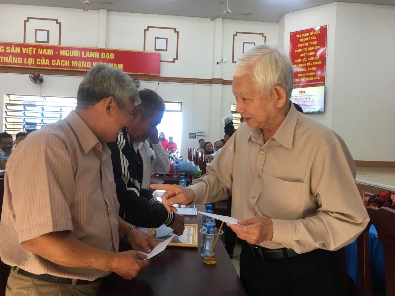 Nguyên Chủ tịch nước Nguyễn Minh Triết trao tặng quà cho các gia đình chính sách ở địa phương. Ảnh: Thoại Phương